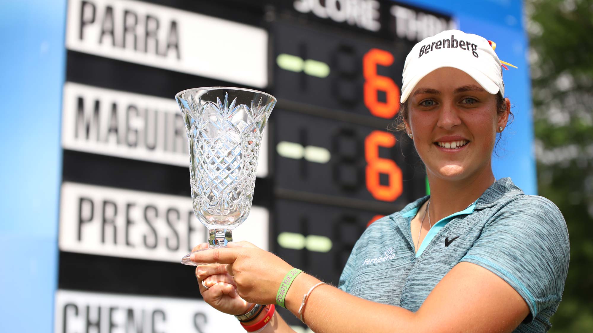 Maria Parra with trophy at leaderboard 