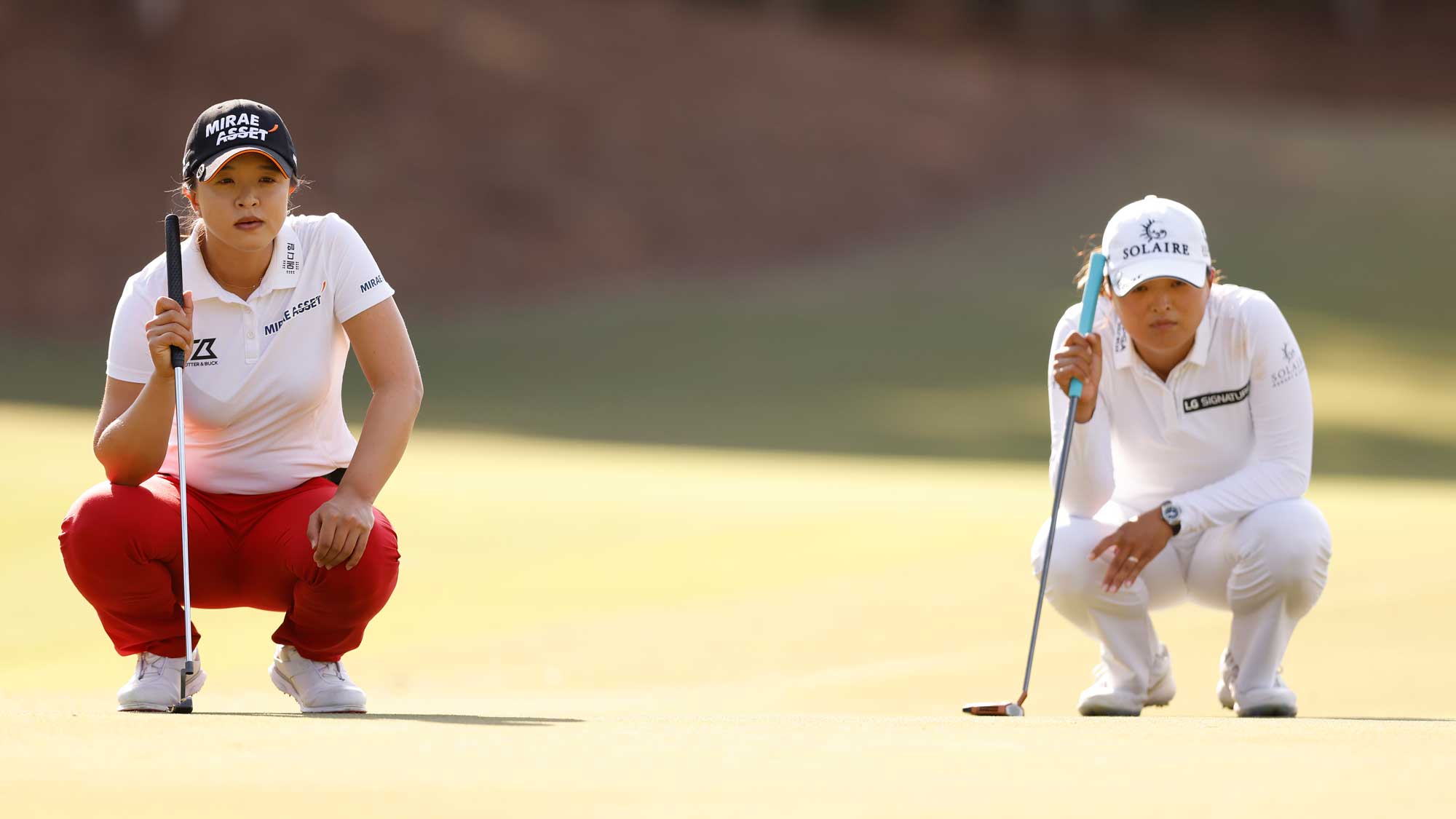 Jin Young Ko of Korea and Sei-Young Kim of Korea look over their putt on the third green during the final round of the CME Group Tour Championship